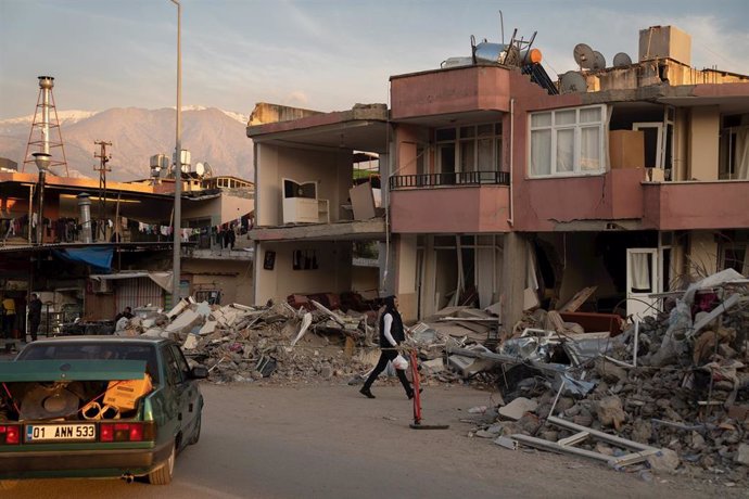 Archivo - Una persona camina por los escombros de los edificios derribados por el terremoto, a 23 de febrero de 2023, en Alejandreta, Turquía