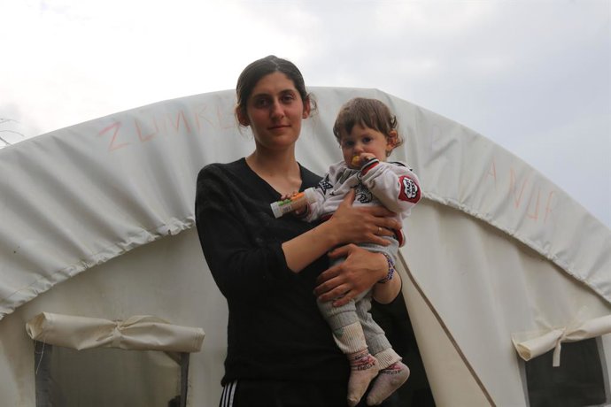 Damla (22) con uno de sus hijos delante de su tienda (Samandag).