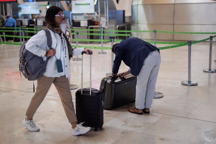 Dos personas con maletas en la terminal T4 del aeropuerto de Adolfo Suárez-Madrid Barajas