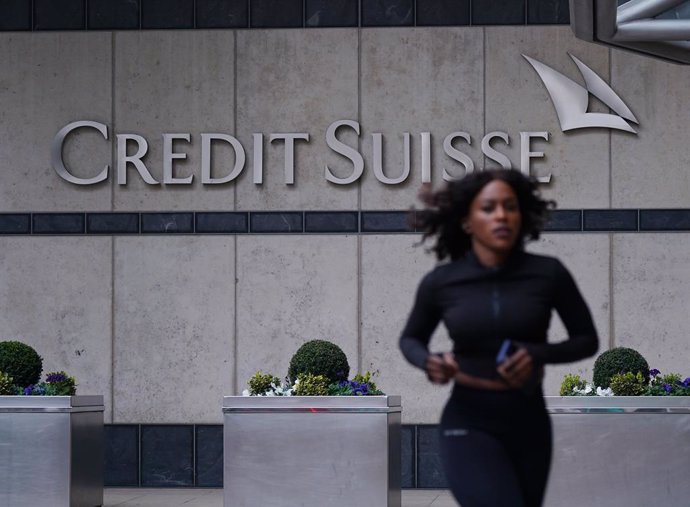 19 March 2023, United Kingdom, London: A woman runs in front of the Credit Suisse UK offices in Canary Wharf. Swiss banking giant UBS is acquiring its ailing smaller rival Credit Suisse in an emergency rescue deal, with the historic mega-merger getting 