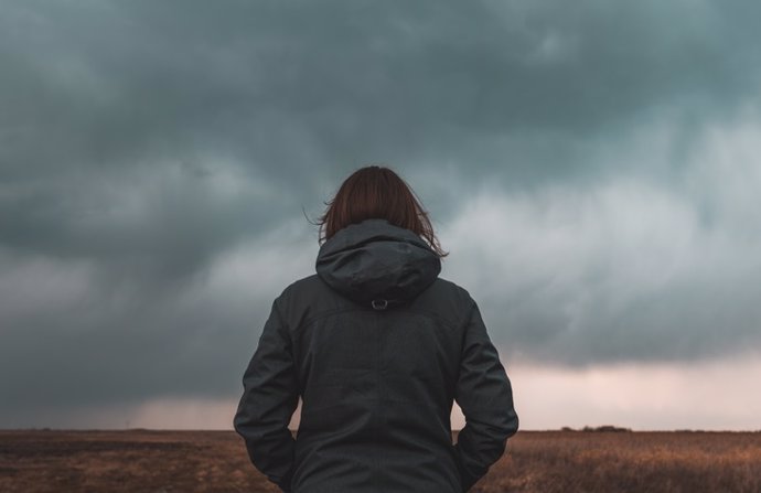 Archivo - Mujer de pie en el prado, mirando el horizonte. Meteorosensible