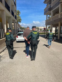 Agentes de la Guardia Civil acompañan a uno de los detenidos.