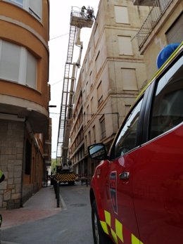 Bomberos del CEIS de la Región de Murcia revisan la fachada de un edificio de la travesía Ramón y Cajal de Lorca por caída de cascotes