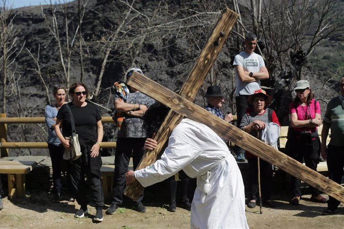 U n hombre porta una cruz en representación de la Subida al Calvario durante el Vía Crucis, en la aldea de Vilar de la parroquia de Villamor, a 7 de abril de 2023, en Folgoso do Courel, Lugo, Galicia, (España)