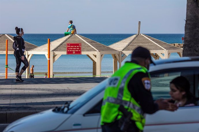 Archivo - 08 January 2021, Israel, Tel Aviv: A man sits on the roof of a pagoda at the beach in Tel Aviv as Israeli police performs checks at a roadblock. Despite leading the global vaccination race Israel started it's third national lockdown in a bid t