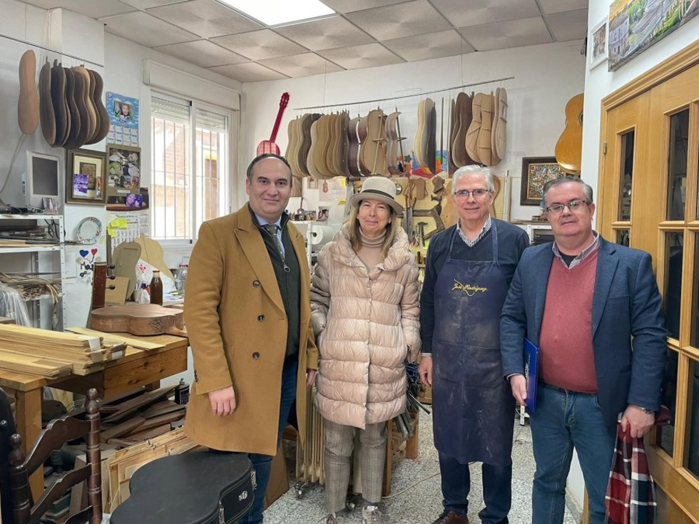 Los profesores de la UCO Manuel Rivera y Ricardo Hernández con la presidenta de la Asociación Contemporánea de Artes y Oficios Artesanos, María Subráts, en el taller del artesano guitarrero José Gutiérrez.
