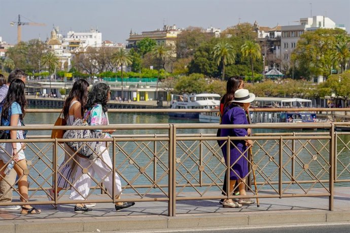 Personas paseando por el puente de San Telmo.