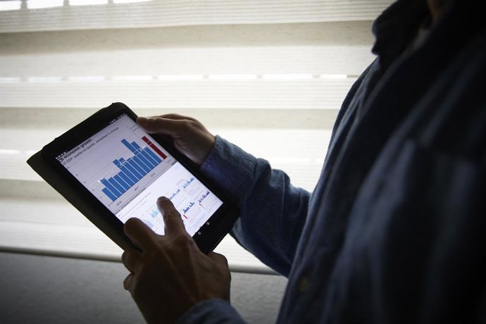 Archivo - Un hombre sujeta una tablet con un gráfico, a 4 de enero de 2022, en Madrid, (España). 