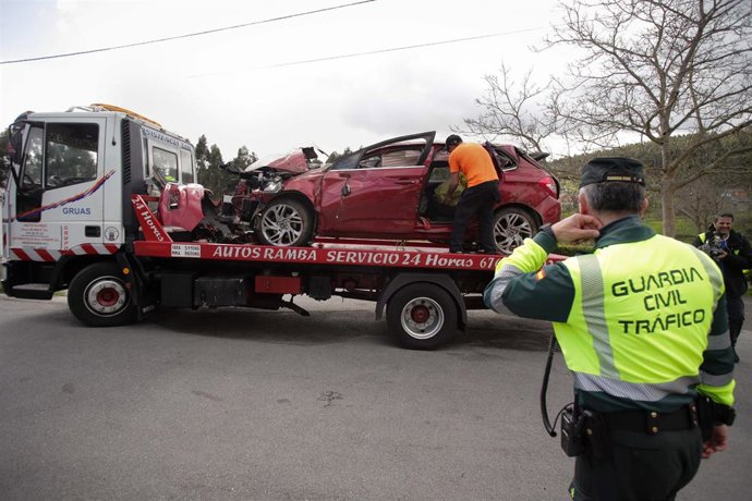 Un Guardia Civil vigila la retirada de un coche siniestrado