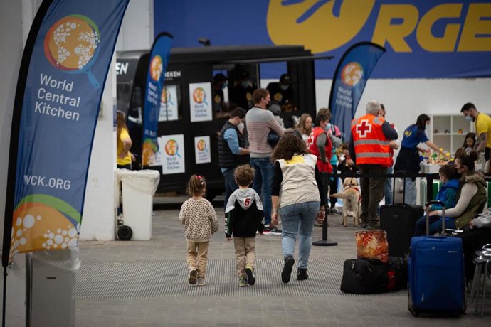 Archivo - Dos niños con una voluntaria traductora, en el centro de refugiados ucranianos, en la Fira de Barcelona, a 8 de abril de 2022