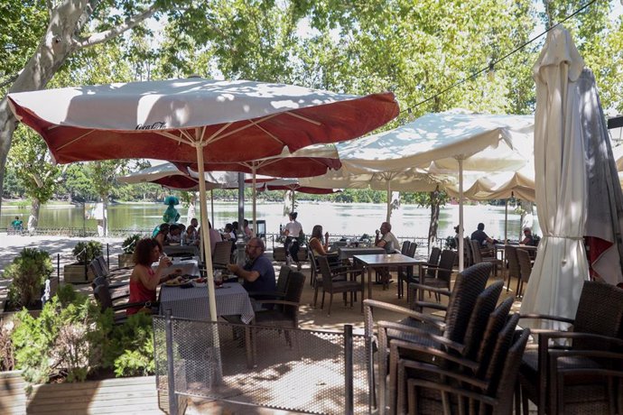 Archivo - Varias personas disfrutan de la hostelería en las terrazas de las inmediaciones del lago de la Casa de Campo 