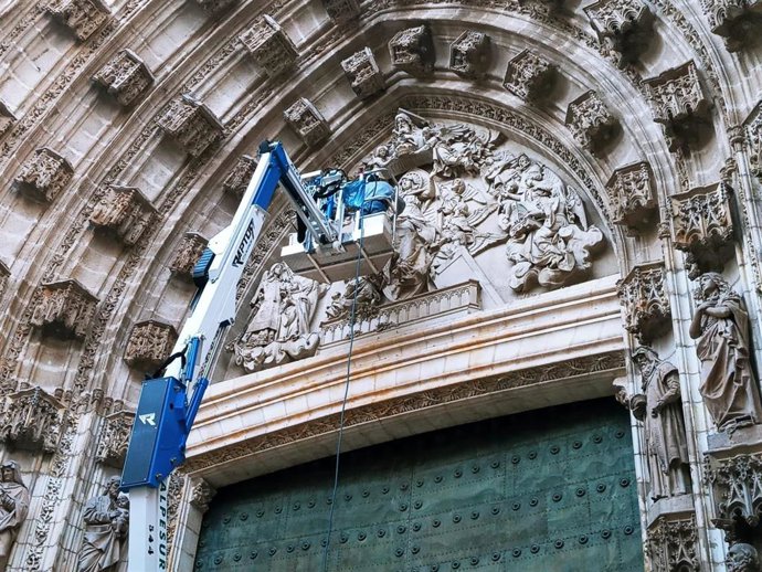 Un operario realiza trabajos de mantenimiento preventivo en la Puerta de la Asunción de la Catedral.