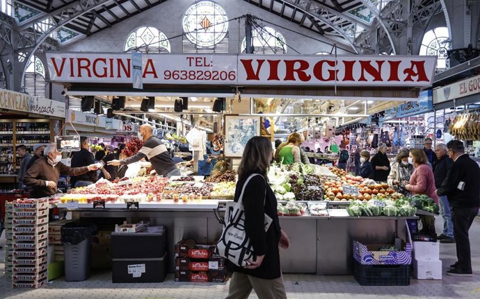 Archivo - Varias personas, con y sin mascarillas, hacen la compra, en el Mercado Central