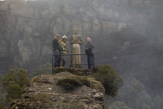 Dos hombres y un guarda forestal observan el monte quemado por un incendio forestal, a 30 de marzo de 2023, en Baleira, Lugo, Galicia (España). El incendio forestal declarado en Baleira (Lugo) continúa activo y afecta ya a 1.100 hectáreas, según recoge 