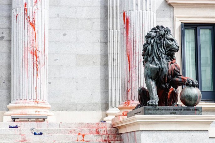Uno de los leones del Congreso de los Diputados y las columnas teñidas con pintura roja por activistas de Futuro Vegetal y Rebelión Científica, a 30 de marzo de 2023, en Madrid (España). Los activistas han echado pintura roja sobre las escalinatas, colu
