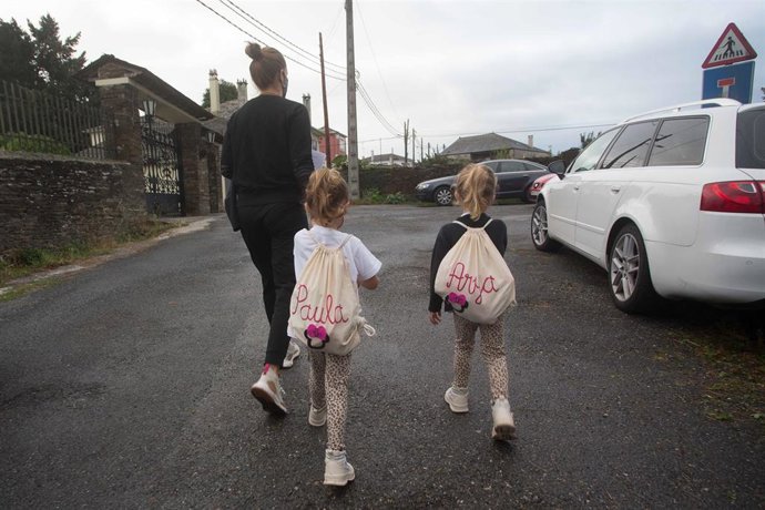 Archivo - Una madre acompaña a sus dos hijas 