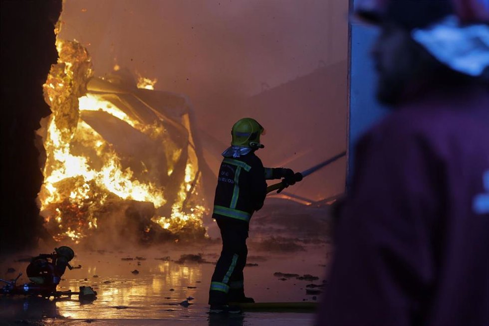Un equipo de bomberos trabaja durante un incendio en una nave de reciclaje en el polígono industrial Sete Pontes. 