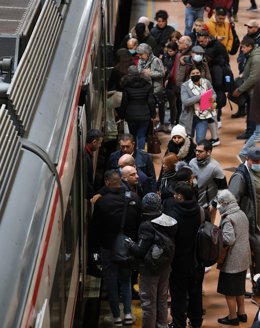Archivo - Varias personas con y sin mascarilla entran y salen de un vagón del tren