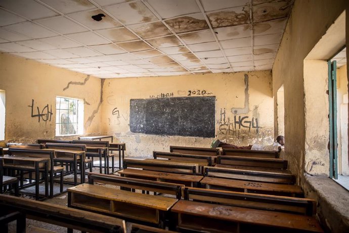 Archivo - Un niño tumbado en una mesa de una clase vacía en el colegio de primaria de Moduganari, Nigeria