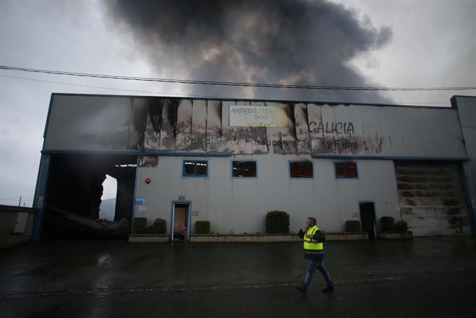 Un equipo de bomberos trabaja durante un incendio en una nave de reciclaje en el polígono industrial Sete Pontes, a 13 de abril de 2023