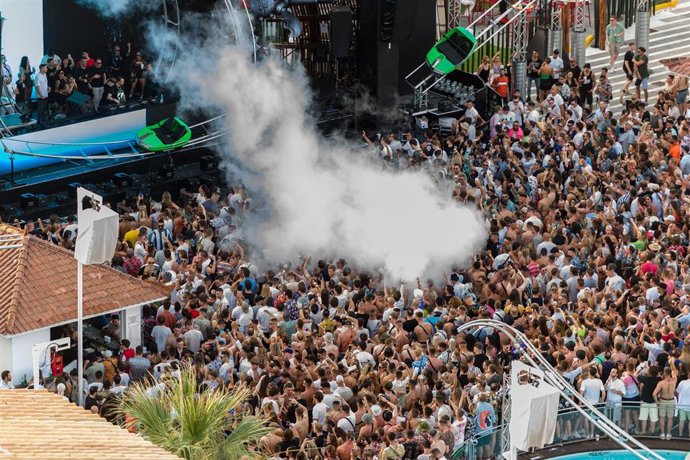 Archivo - Varias personas concentradas en un escenario durante una fietsa en Ibiza. 