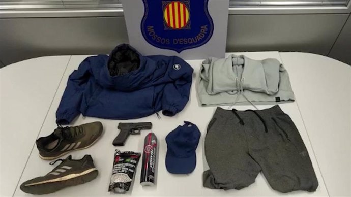 Ropa y pistola simulada encontradas por los Mossos d'Esquadra en el domicilio del acusado.