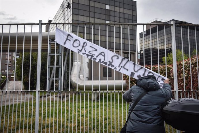 Un simpatizante del ex primer ministro de Italia Silvio Berlusconi coloca una pancarta en la que pone 'Fuerza Silvio' frente al hospital en el que se encuentra ingresado en Milán