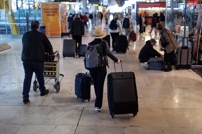Varias personas con maletas en la terminal T4 del aeropuerto de Adolfo Suárez-Madrid Barajas, a 5 de abril de 2023, en Madrid (España).  