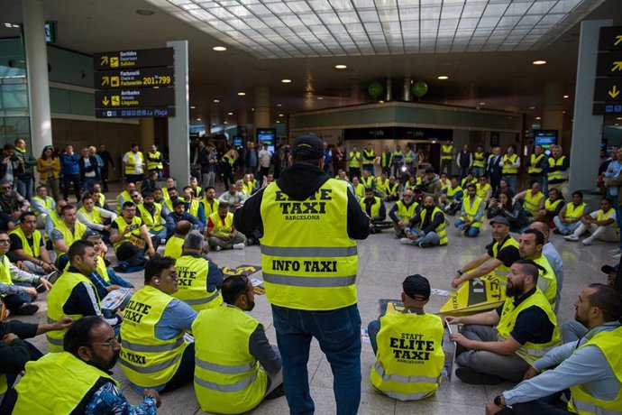 Un grupo de taxistas se reúnen durante una concentración en la T1 del aeropuerto de Barcelona, a 17 de abril de 2023, en Barcelona, Catalunya (España). El sector del taxi emprende hoy cuatro días seguidos de protestas en el Aeropuerto de Barcelona para 
