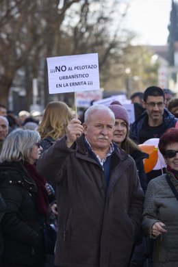Archivo - Un hombre lleva una pancarta que reza 'No al pelotazo urbanístico' en la Ermita del Santo 