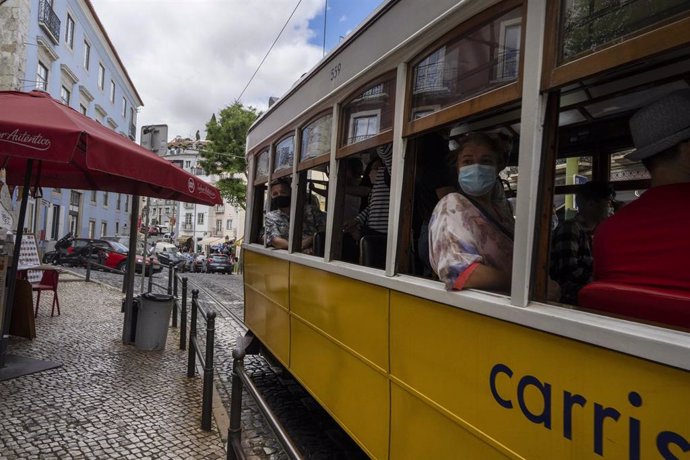 Archivo - Personas con mascarilla en un tranvía de Lisboa