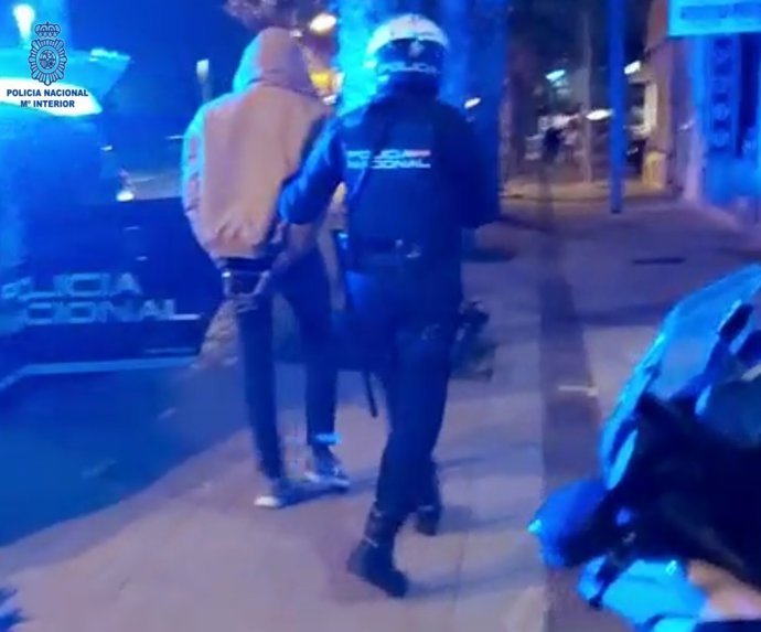 Un agente de la Policía Nacional junto al detenido.