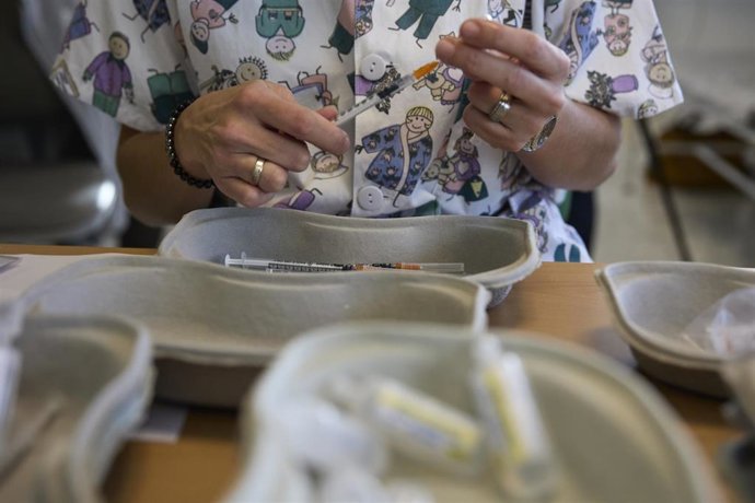 Archivo - Un profesional sanitario sostiene una jeringuilla con una dosis de la vacuna contra el Covid-19
