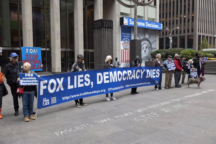 Archivo - 01 November 2022, US, New York: Demonstrators hold a banner reads "Fox Lies, Democracy Dies." during a protest outside Fox News headquarters, accusing the network of spreading propaganda that threatens fair and free elections a week before the