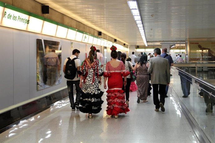 Mujeres vestidas de flamenca utilizan el suburbano para ir al recinto ferial.