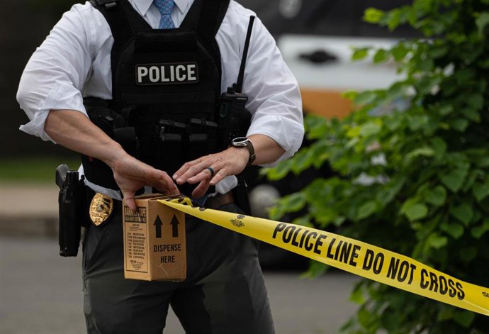 Archivo - Un agente de policía de Estados Unidos acordona la escena de un crimen.