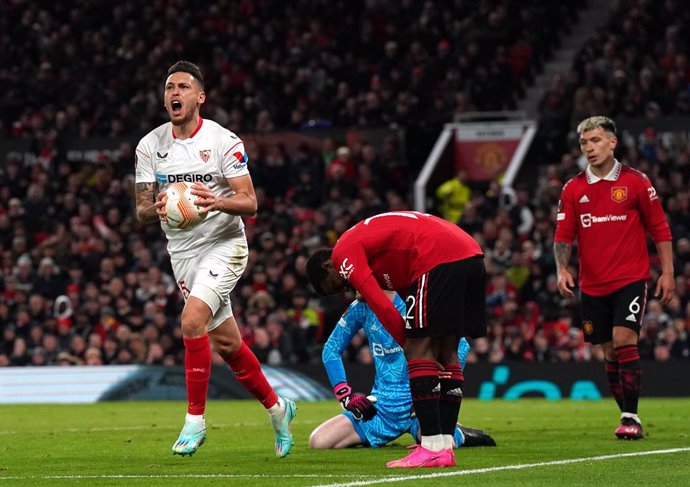 13 April 2023, United Kingdom, Manchester: Sevilla's Lucas Ocampos (L) celebrates their side's first goal of the game, an own goal from Manchester United's Tyrell Malacia during the UEFA Europa League quarter-final first leg soccer match between Manches