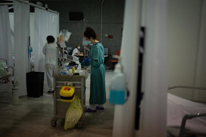 Archivo - Personal sanitario junto a los boxes de la Unidad de Cuidados Intensivos