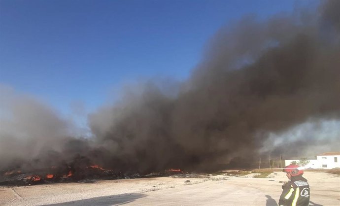 Los bomberos de la Diputación intervienen ante el incendio declarado en una antigua fábrica de neumáticos en Puente Genil.