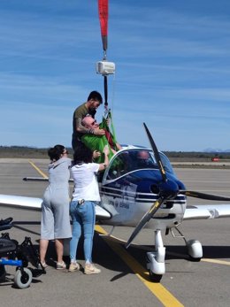 Uno de los usuarios del CRE accede a la cabina de la aeronave durante la celebración de la jornada de vuelo adaptado