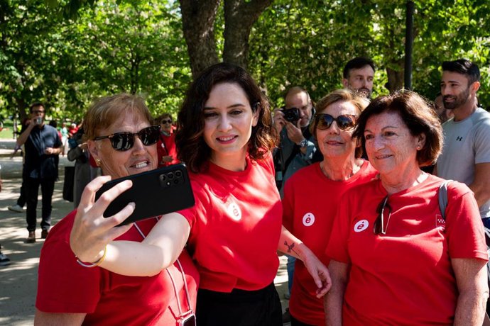 La presidenta de la Comunidad de Madrid, Isabel Díaz Ayuso se hace una foto con simpatizantes a su llegada a las actividades del programa Enforma 2023, en el Parque de El Retiro