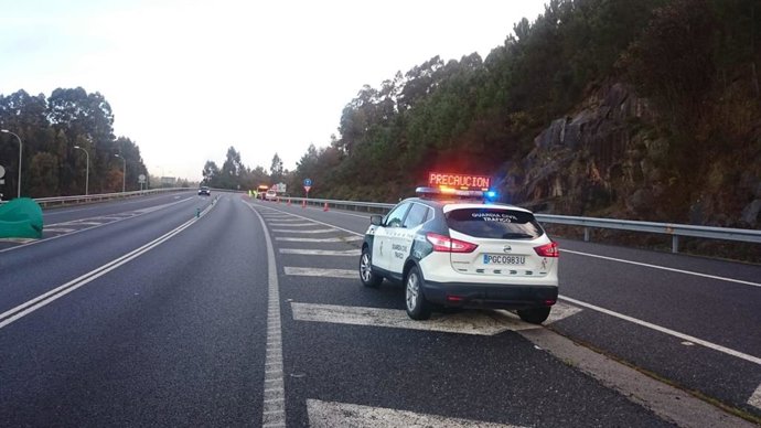 Archivo - Vehículo de la Guardia Civil dando la señal de alto en la carretera.