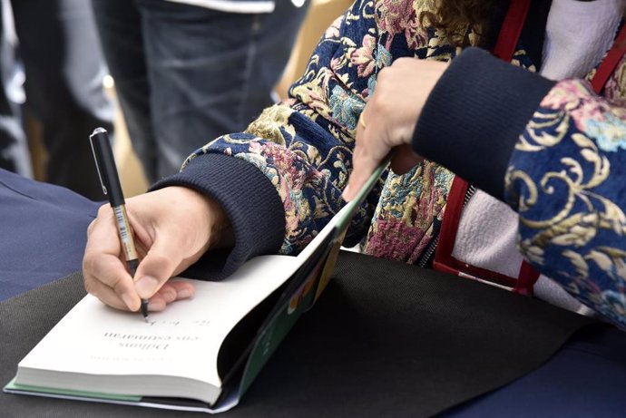 Archivo - Una escritora firmando su libro en Sant Jordi de 2021, en Barcelona.