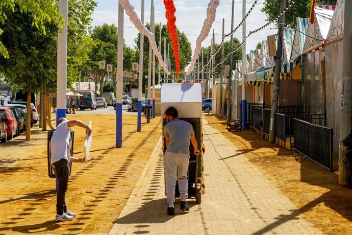 Imagen de operarios trabajando en los preparativos de la Feria de Abril de Sevilla. 