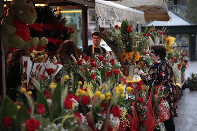 Una dona en una parada de flors durant la celebració de Sant Jordi a Barcelona