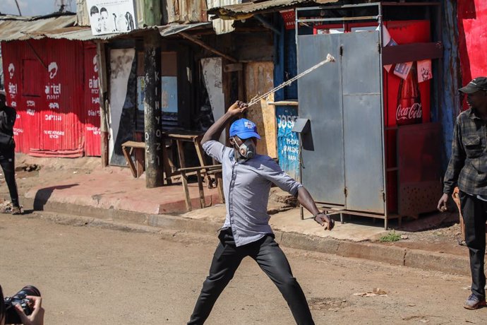 March 27, 2023, Nairobi, Kenya: A protestor throws stones towards the anti-riot police in Kibera during a demonstration called by Azimio party leader Raila Odinga over the cost of living and president William Ruto's administration.