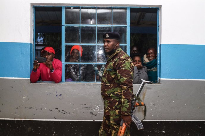 Archivo - April 14, 2022, Nakuru, Rift Valley, Kenya: A police officer patrols around the polling station as a group of people follow the tallying of votes during United Democratic Alliance Party Primaries. United Democratic Alliance (UDA), a political pa