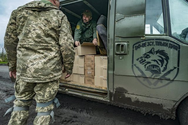 Un voluntario reparte suministros a un militar ucraniano en Donetsk.