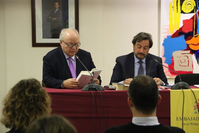 Carlos Pérez-Desoy (izquierda) durante la lectura del Quijote, con el ministro consejero de la embajada, Enrique Conde.