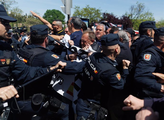 Varios agentes de Policía Nacional frente a varios simpatizantes de la Falange, antes de la llegada del coche fúnebre con los restos de José Antonio Primo de Rivera, en el cementerio sacramental de San Isidro, a 24 de abril de 2023, en Madrid (España). Lo